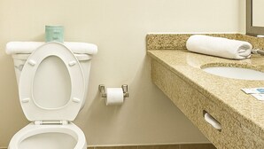 Un baño con inodoro, toalla y lavabo.