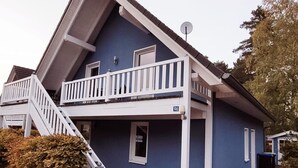 Une maison à deux étages avec un balcon, un escalier et une plaque portant le numéro « 96 ».
