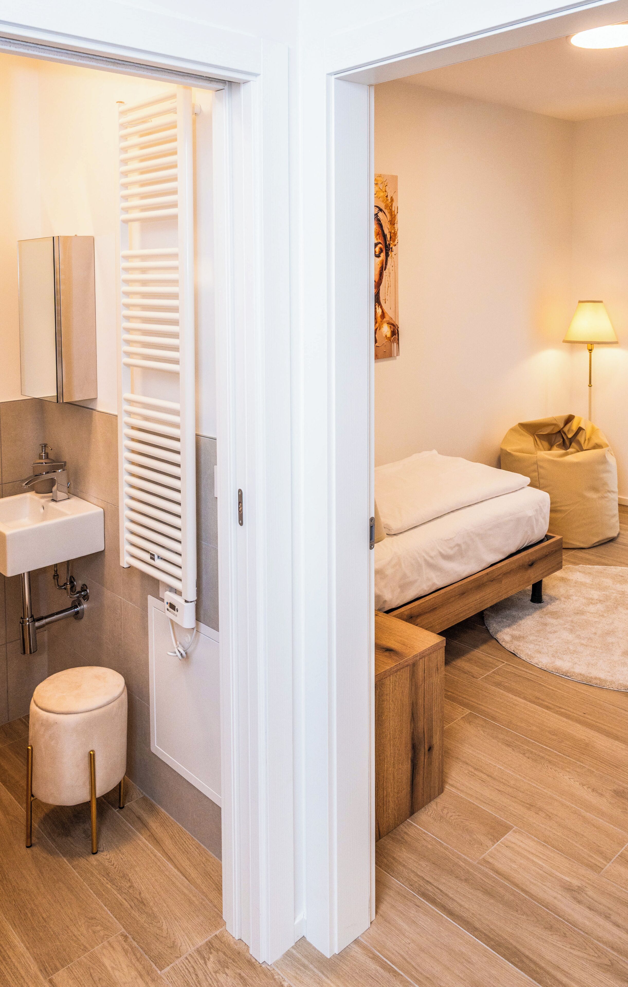 Uma casa de banho moderna com lavatório, toalheiro e radiador.