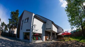 A two-story building with a storefront labeled 'Hostel' and a covered outdoor seating area.