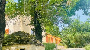 A stone building with a small opening, surrounded by greenery and a road. - Vacation home for 6 in a quiet location (Saint-Cybranet)