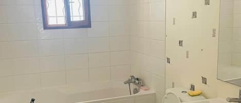 A bathroom with a bathtub, toilet, and sink.