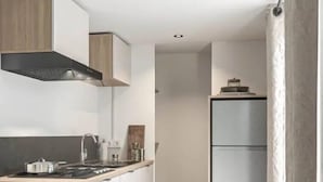 Uma cozinha moderna com fogão, armários e geladeira.