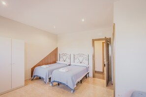 Un dormitorio con dos camas, un armario y una puerta que da a otra habitación.