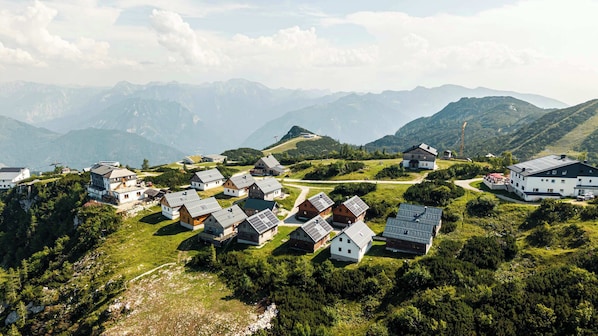 A village with houses, a road, and mountains in the background.