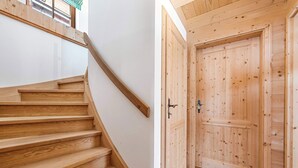 A wooden staircase leading to a room with a wooden door.