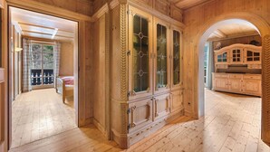 Una habitación con paneles de madera, un armario grande, una cama y vistas a través de un arco.