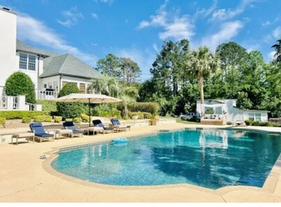 Resort style 5-bedroom lake house with white sand beach, pool, and pool house.