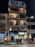 Um edifício de vários andares com um restaurante no térreo chamado 'BELEZZA' e outro restaurante no segundo andar chamado 'melhan'.