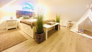A bedroom with a bed, bedside tables, a bench, a tent-like structure, and large potted plants. - Idyllic Thatched Apartment, Schwalbe Wieck Darß, 2 Bedrooms, 2 Balconies, Near Water (Wieck auf Darß)
