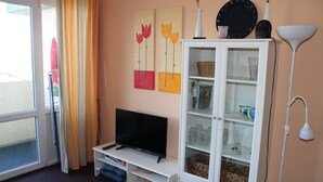 A living room with a television, a cabinet with glass doors, and artwork on the wall. - Holiday apartment on the Baltic Sea E312 (Schönberg OT Holm)