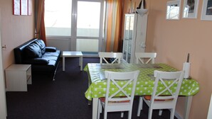 A room with a dining table, chairs, a sofa, and a cabinet. - Holiday apartment on the Baltic Sea E312 (Schönberg OT Holm)