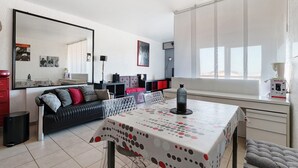 Un salon moderne avec une table à manger, un canapé et une grande fenêtre.