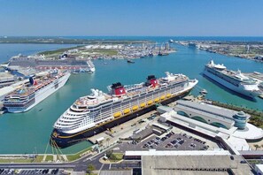 A large cruise ship docked at a port with multiple terminals and a parking area. - Coastal Getaway: Near FIT, Downtown & Beach (Melbourne)