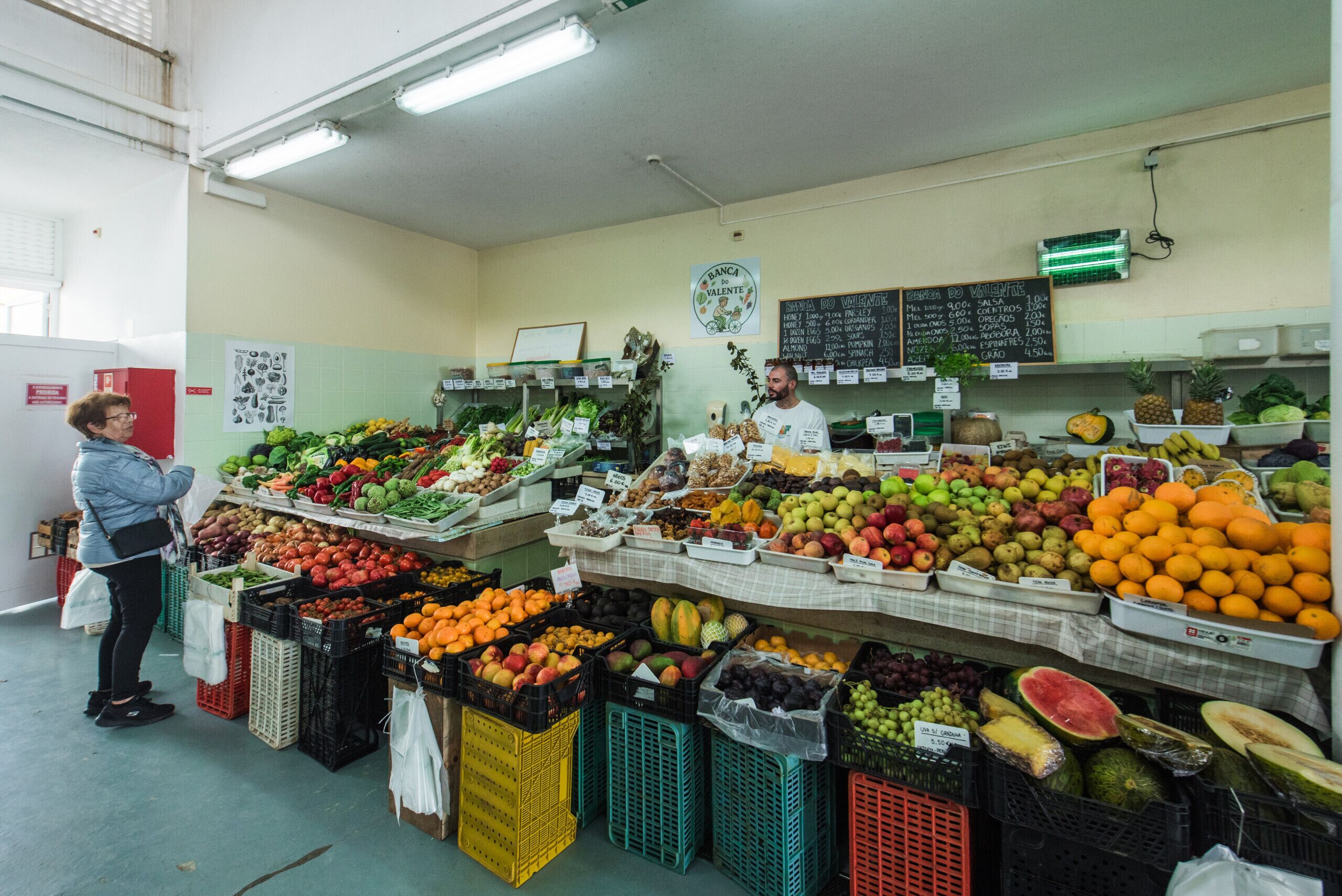 A grocery store with various fruits and vegetables on display.