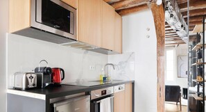Una cocina moderna con electrodomésticos de acero inoxidable, armarios de madera y un salpicadero de mármol.