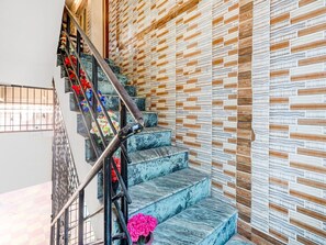 Un escalier avec des marches en marbre et un mur orné de motifs.