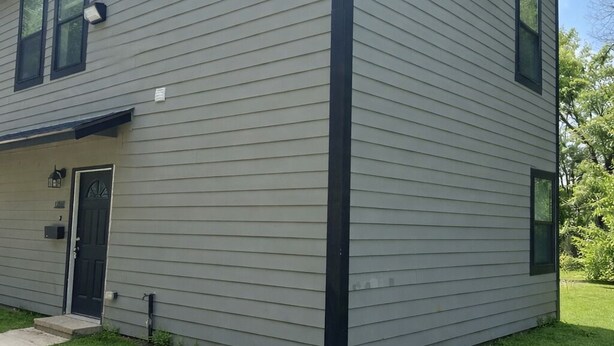 A two-story building with a flat roof, a front door, and a small porch. - 2bed 2bath apartment in Baton Rouge 6 min. from LSU fast WiFi, and free parking (Baton Rouge)