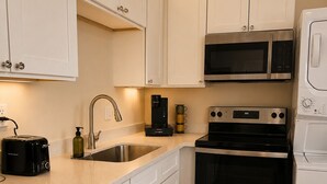 A kitchen with white cabinets, a stainless steel microwave, a coffee maker, a toaster, and a sink. - 2bed 2bath apartment in Baton Rouge 6 min. from LSU fast WiFi, and free parking (Baton Rouge)