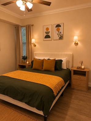 A bedroom with a bed, bedside tables, a ceiling fan, wall-mounted lamps, and artwork. - 2bed 2bath apartment in Baton Rouge 6 min. from LSU fast WiFi, and free parking (Baton Rouge)