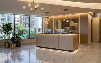 Un comptoir d’accueil au design moderne, de grandes fenêtres et un lustre.