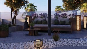 A rooftop patio with a circular seating area, a table, and a lamp. - La Terrasse Hotel (Jeddah)