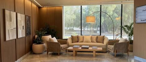 Una sala moderna con un conjunto de sofá, una mesa de centro y plantas en macetas.