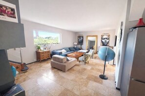 Un salon moderne avec un canapé, une table basse et un globe terrestre bleu.