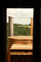 Una sauna de madera con vistas a un paisaje boscoso a través de una ventana.
