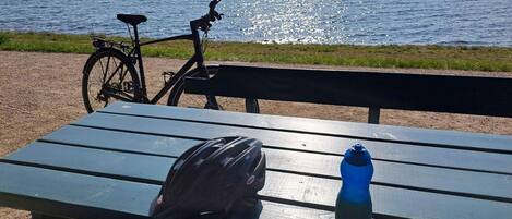 A bench with a bicycle and a water bottle on it.