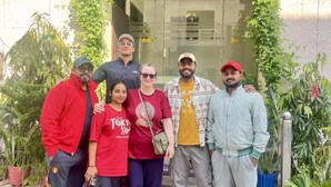 A group of people standing in front of a building with glass doors and potted plants. - Sia Taj Hotel Agra Nearest Taj Mahal (Agra)