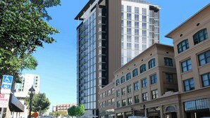A multi-story building with a modern architectural design, featuring a mix of glass and solid facade elements.