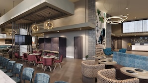 A modern interior with a dining area, seating arrangements, and a reception desk.