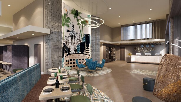 A modern hotel lobby with a reception desk, seating areas, and a decorative wall.