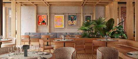 A restaurant interior with round tables, checkered chairs, and artwork on the walls.