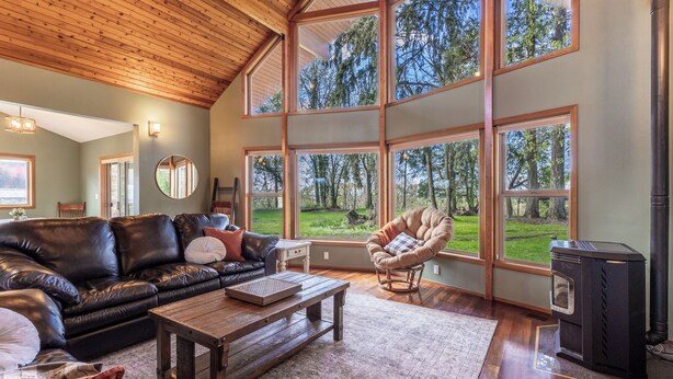 A spacious living room with a leather sofa, a wooden coffee table, and a large fireplace.