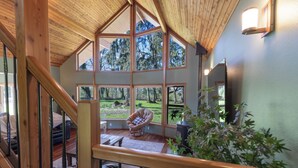 A spacious room with large windows, a wooden ceiling, and a view of the outdoors.