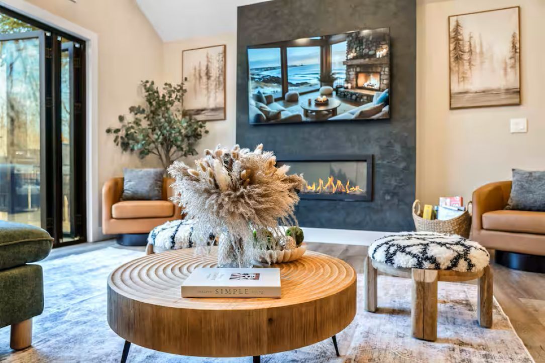 A modern living room with a fireplace, a round coffee table, and a sofa.