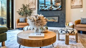 A modern living room with a fireplace, a round coffee table, and a sofa. - Creek Retreat w/ Secluded 18-Acres, Hot Tub, Sauna (East Stroudsburg)