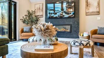 A modern living room with a fireplace, a round coffee table, and a sofa.