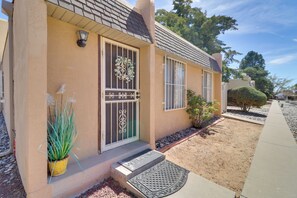 A house with a welcoming front door, a small porch, and a well-maintained garden. - 3 Mi to Uptown Abq! Pet-friendly Condo w/ Patio (Albuquerque)