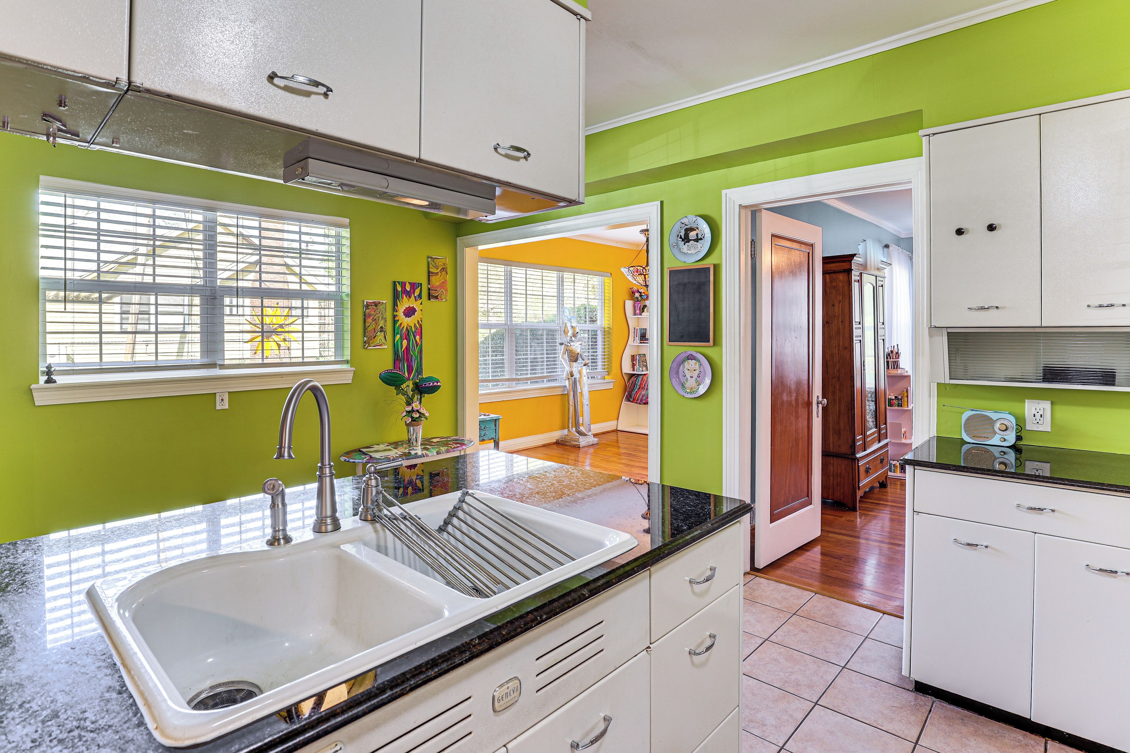 A kitchen with a sink, cabinets, and a window.