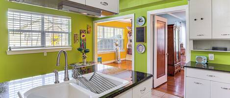 A kitchen with a sink, cabinets, and a window.