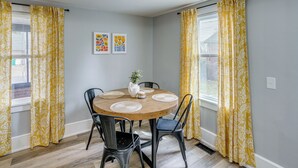A dining area with a round table, chairs, and a vase with flowers. - 4 Mi to Waterfront: 2-unit Combo in Kingston! (Kingston)
