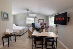 A bedroom with a bed, a desk with a chair, a TV, and a ceiling fan. - Peaceful Downtown Clermont Studio Near Waterfront Park (Clermont)