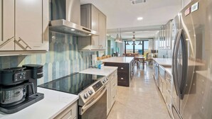 Een moderne keuken met een koffiezetapparaat, fornuis, oven en koelkast.