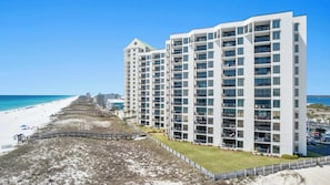 A beachfront hotel with multiple floors, balconies, and a beach access walkway. - Navarre Towers 101 - 3 Bedroom (Navarre)