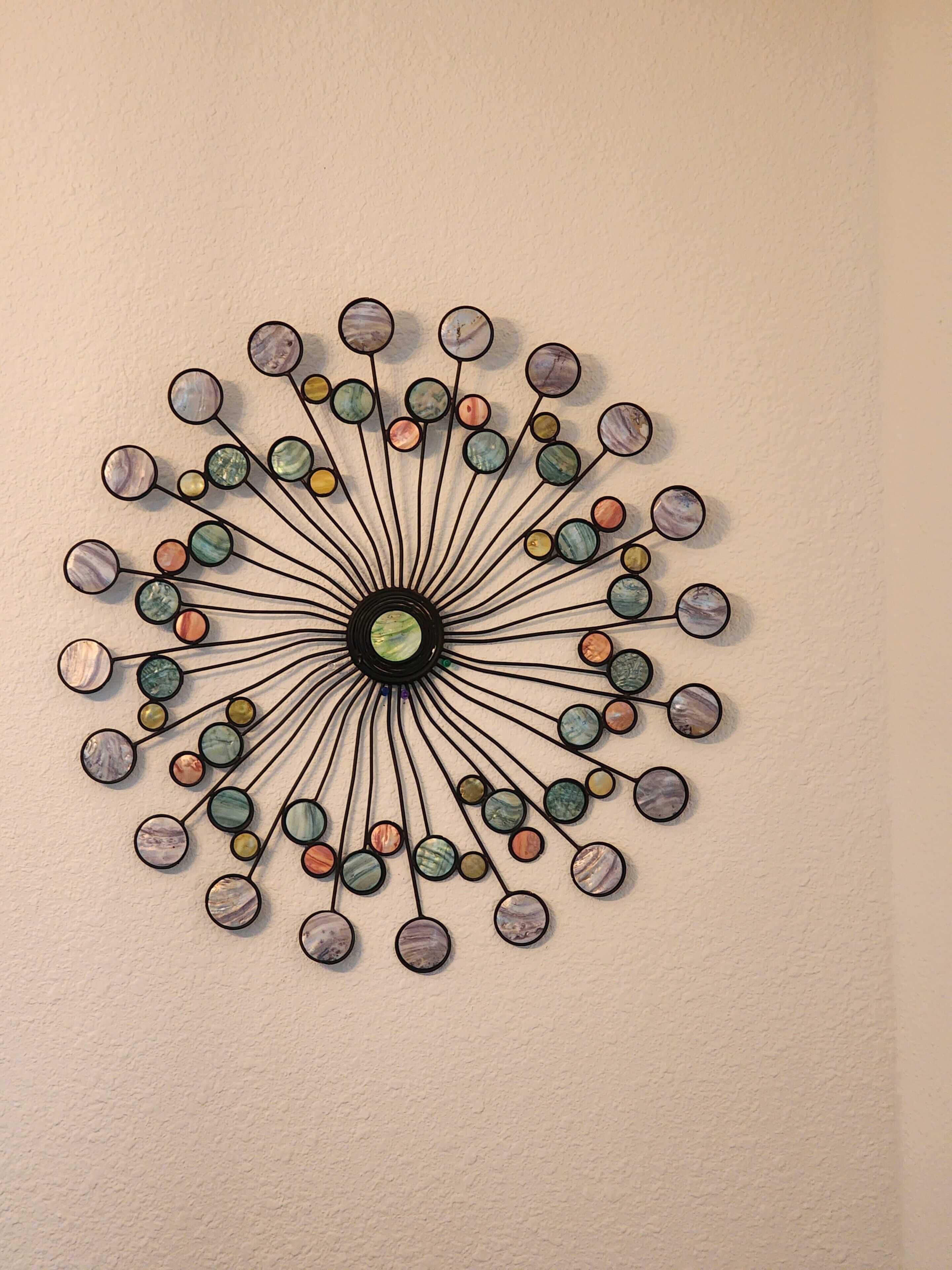 A circular wall art with a central black circle and multiple colored circles connected by lines.