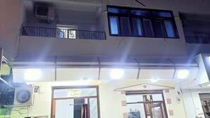 A building with multiple windows, an air conditioning unit, and a sign with Arabic text. - Marsa allan star (Marsa Alam)