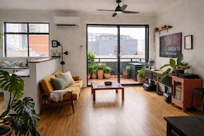 Un salon moderne avec un canapé, une table basse et des plantes en pot.